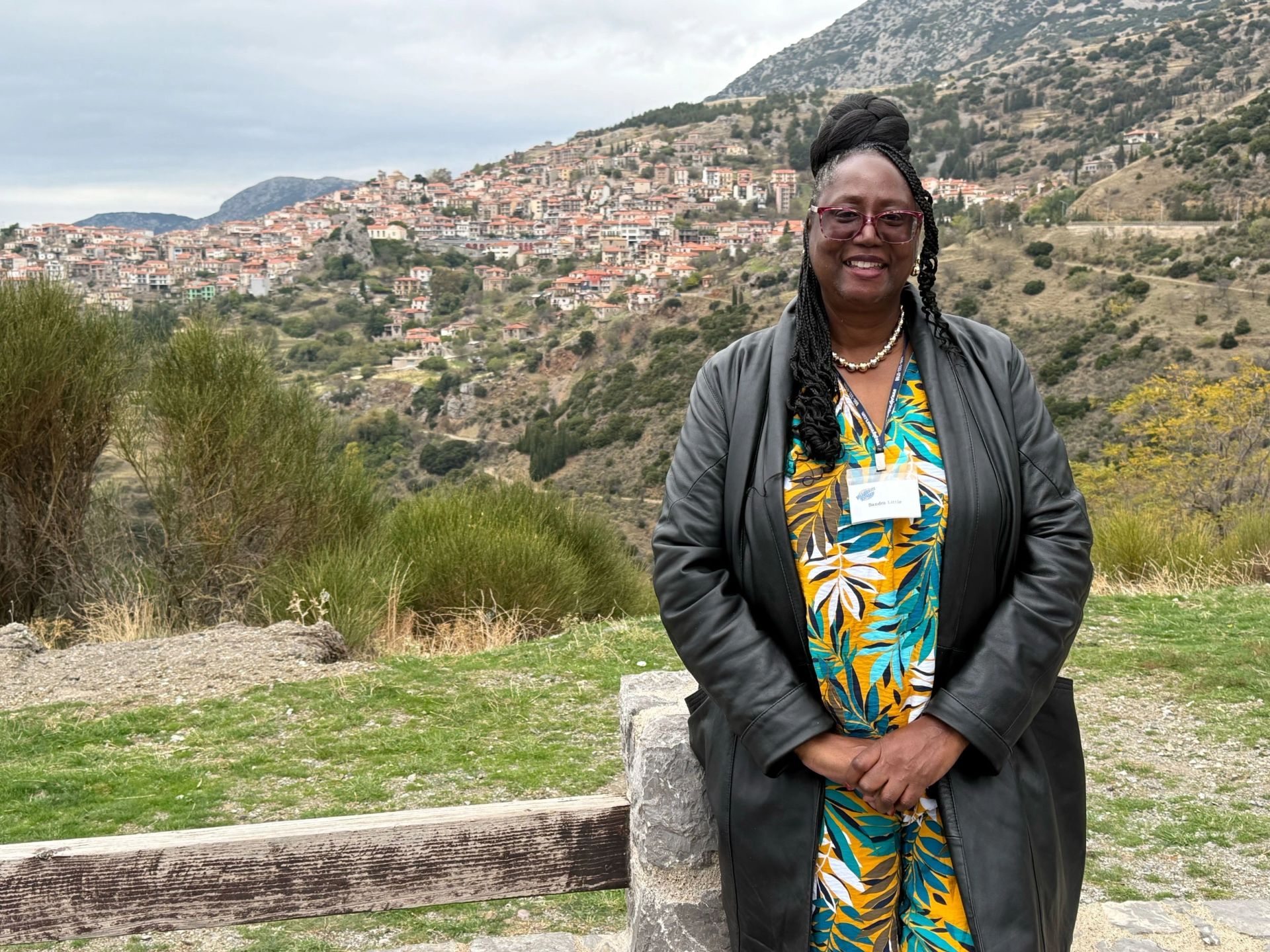Dr. Sandra D. Little standing on a hillside overlooking a Greek mountain village.